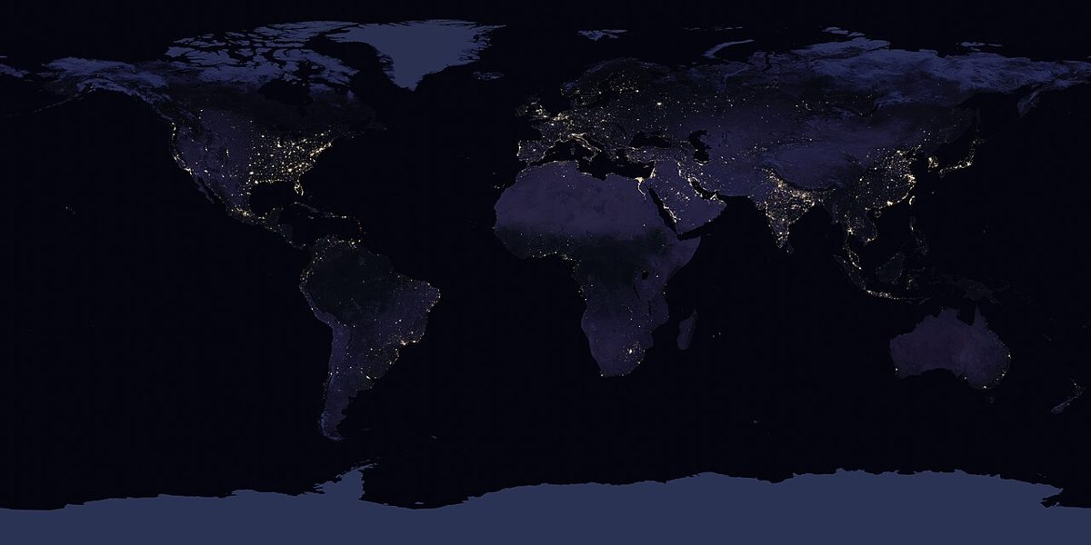 Satellite view of Earth at night showing networks of artificial light