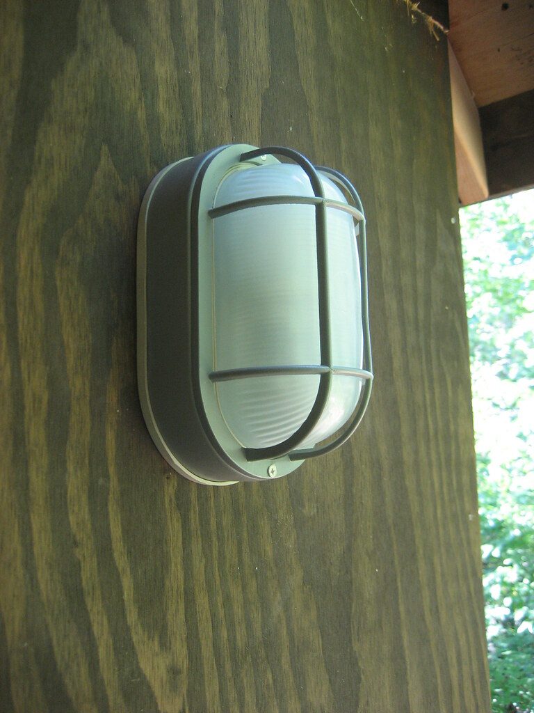 Porch light glowing above a house entrance after dark