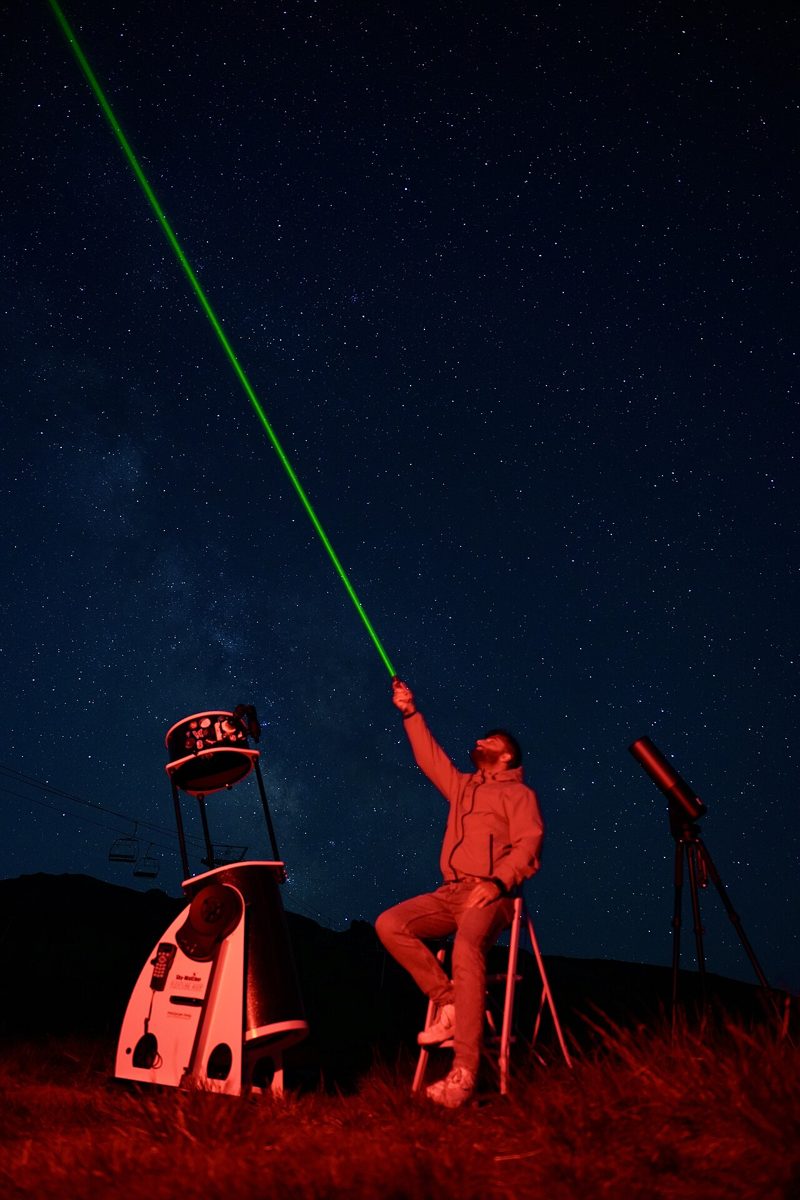 People observing the night sky through a telescope at an astronomy camp