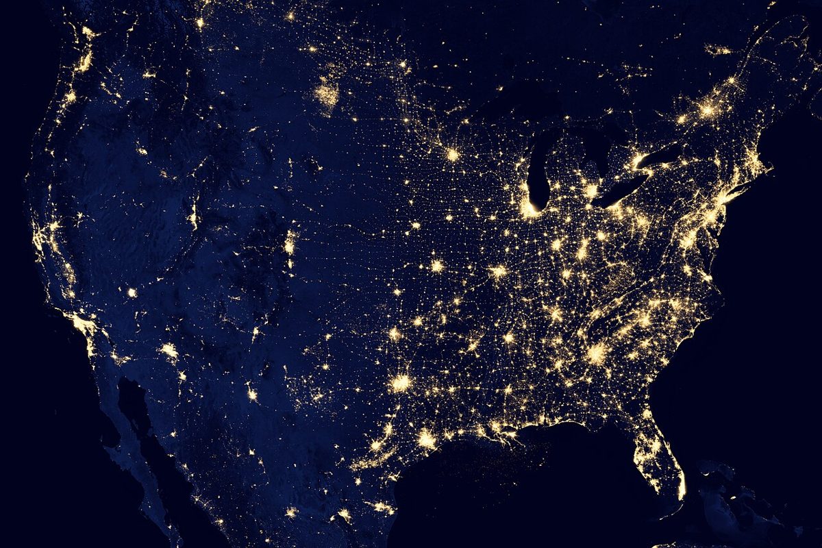 The United States photographed at night from space, glowing with city lights